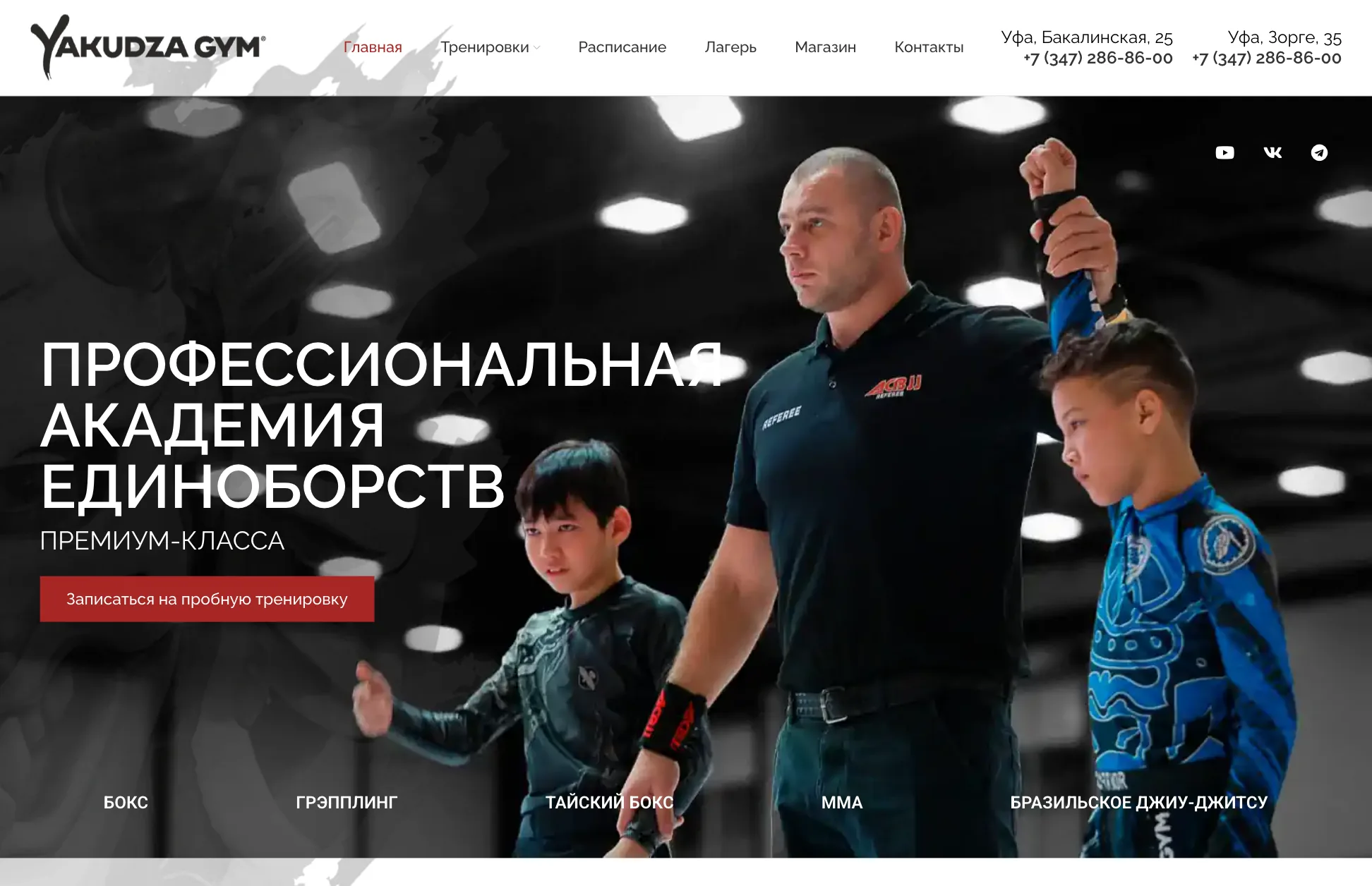 Первый экран сайта Yakudza Gym: судья поднимает руку юного бойца, кнопка записи на пробную тренировку